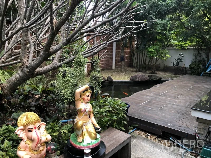 Detached House for rent or sale in Saphan Sung, Bangkok - Close-up of koi pond garden with statues, plants and timber deck