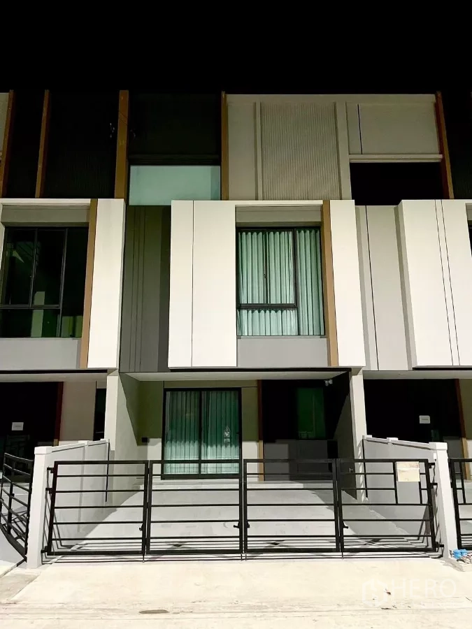 Townhouse for rent in Samut Prakan - Contemporary 2.5-storey townhouse facade with gated two-car parking.