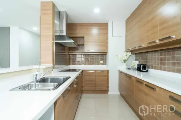 公寓 出售在Watthana, Bangkok - U形现代厨房，木质橱柜、白色台面、不锈钢水槽与抽油烟机