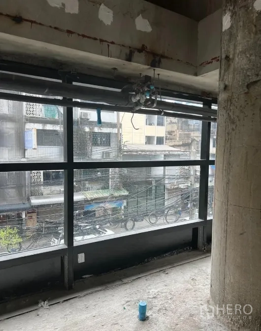 Retail Space for rent - Long band of windows overlooking nearby buildings with existing plumbing points below.