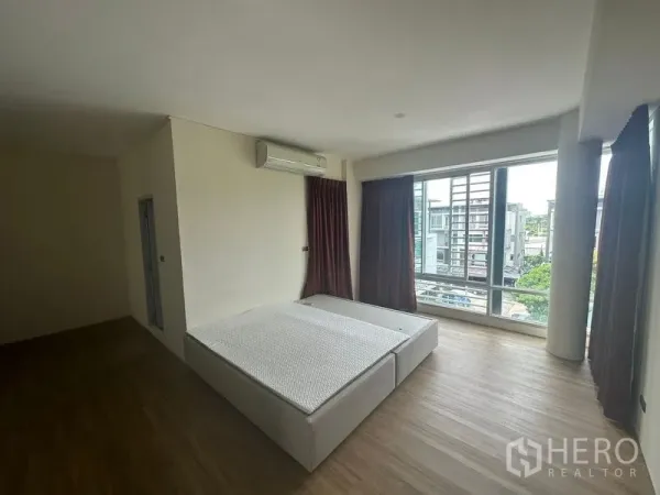 带办公室的家 出租在Wang Thonglang, Bangkok - 采光充足的卧室，落地窗、木地板与空调。