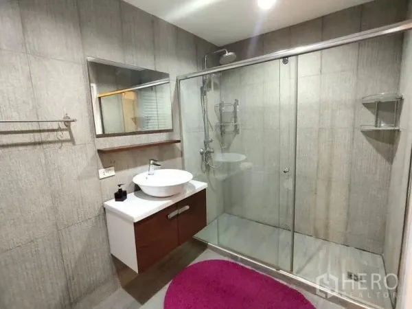 Condominium for rent or sale in Bang Rak, Bangkok - Contemporary bathroom with vessel sink and large glass‑enclosed shower on gray tiles.