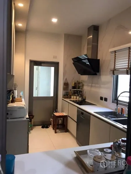 Detached House for sale in Saphan Sung, Bangkok - Sleek galley kitchen with stone counters, cooktop, extractor hood and a window.