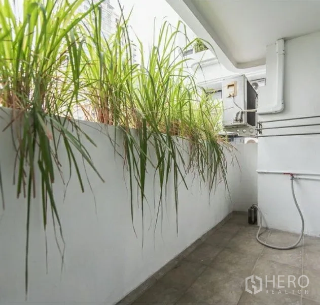 公寓 出租或出售在Watthana, Bangkok - 带绿植花槽的私人阳台，铺砖地面并设实用区。