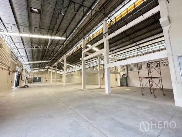 工厂 出租在Lam Luk Ka, Pathum Thani - 宽敞仓库大厅，高钢桁架屋顶与混凝土地面。