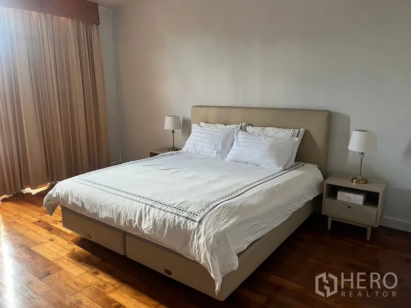公寓 出租在Sathon, Bangkok - 主卧配软包大床与床头柜，木地板温馨