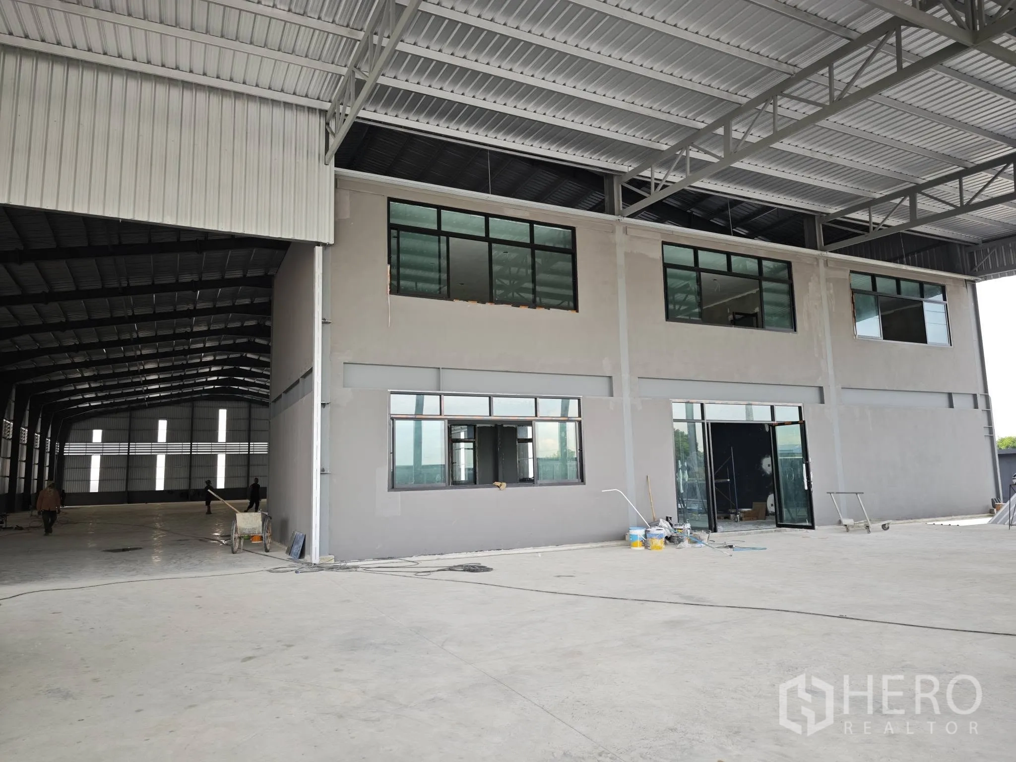 仓库 for rent or sale in Bang Phli, Samut Prakan - 仓库内有顶装卸区与两层办公楼，地面为宽阔混凝土。