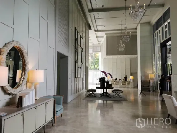 Condominium for rent in Pathum Wan, Bangkok - Grand double-height lobby with chandeliers, mirrors and elegant seating.