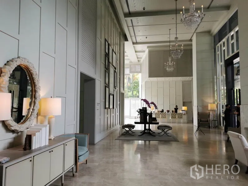 Condominium for rent in Pathum Wan, Bangkok - Grand double-height lobby with chandeliers, mirrors and elegant seating.