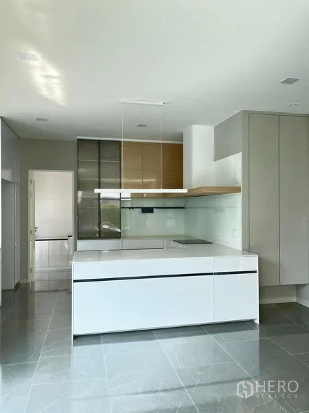 Detached House for rent or sale - Contemporary kitchen with glossy white island, glass backsplash, and built-in cabinetry.