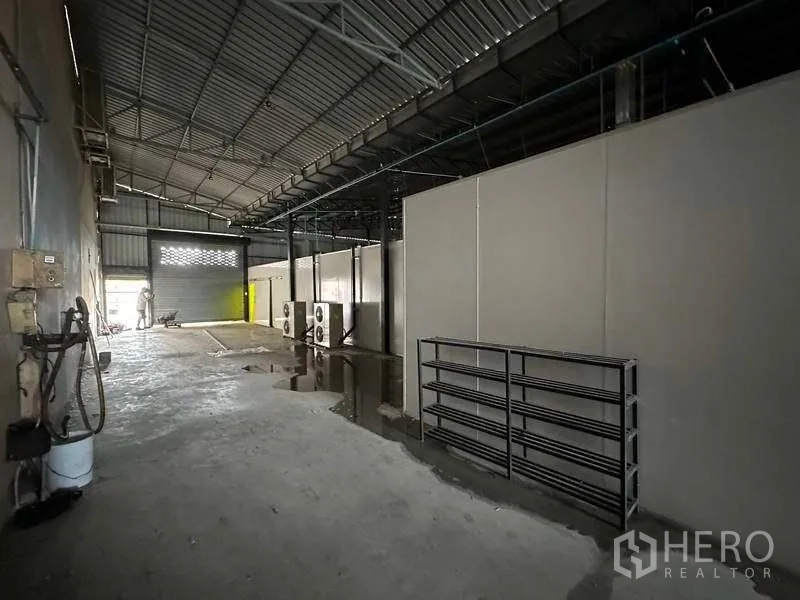 货栈 出租在Khlong Luang, Pathum Thani - 高挑仓库通道，隔断分区与远端卷闸门。