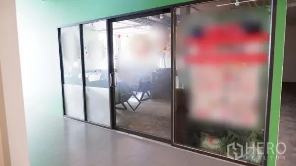 Retail Space for rent in Watthana, Bangkok - Glass-fronted retail unit with sliding door and frosted panels along an indoor corridor.