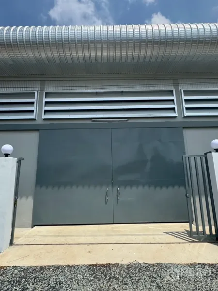 Warehouse for rent or sale in Nong Chok, Bangkok - Close-up of secure double steel doors and ventilation panels on a newly built warehouse facade.