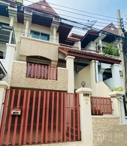 联排别墅 出租在Prawet, Bangkok - 曼谷三层联排别墅外观，红色金属大门与阳台。