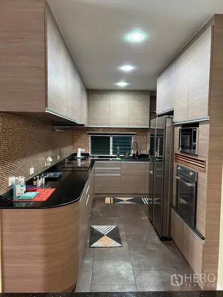 独立式住宅 出租在Bang Kapi, Bangkok - U形厨房，木质橱柜、黑色花岗岩台面与嵌入式家电。