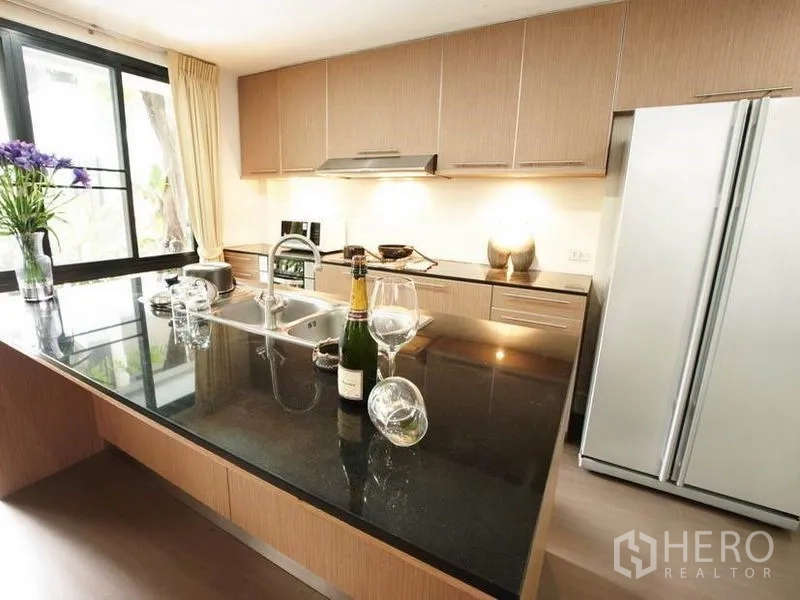 Detached House for rent in Khlong Toei, Bangkok - Modern kitchen with island, stone countertop and built-in cabinets