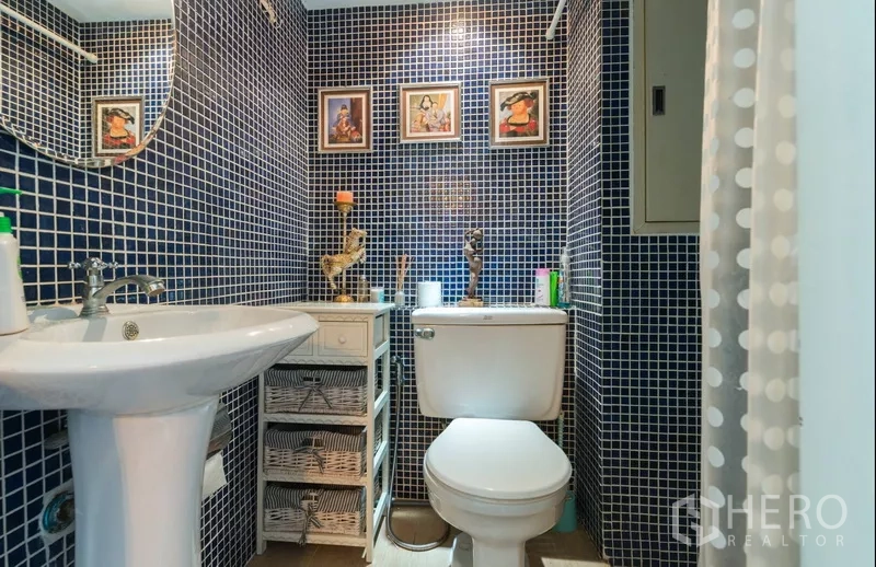 Detached House for rent in Phra Khanong, Bangkok - Bathroom finished with blue mosaic tiles, pedestal sink, toilet and framed decor.
