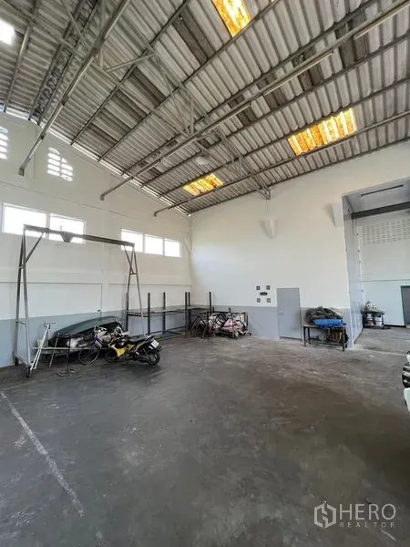 货栈 出租在Thung Khru, Bangkok - 仓库角落视角，层高充足，侧窗与混凝土地面和设备架。