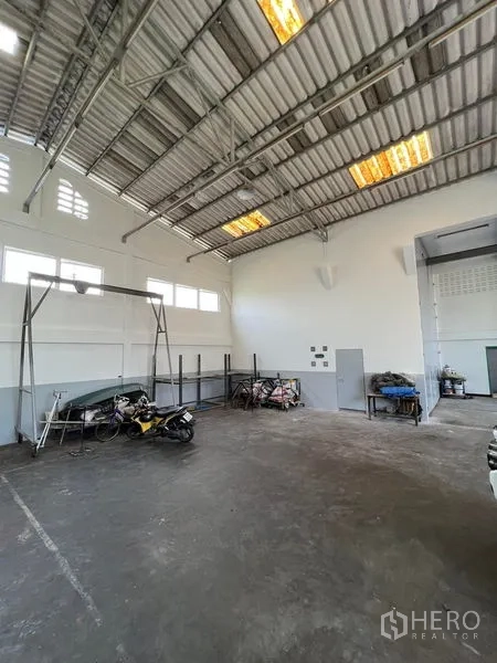 货栈 出租在Thung Khru, Bangkok - 仓库角落视角，层高充足，侧窗与混凝土地面和设备架。
