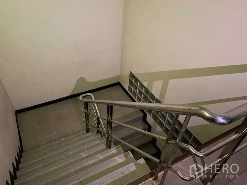 Retail Space for rent - Stairwell with stainless‑steel handrail inside a commercial building.