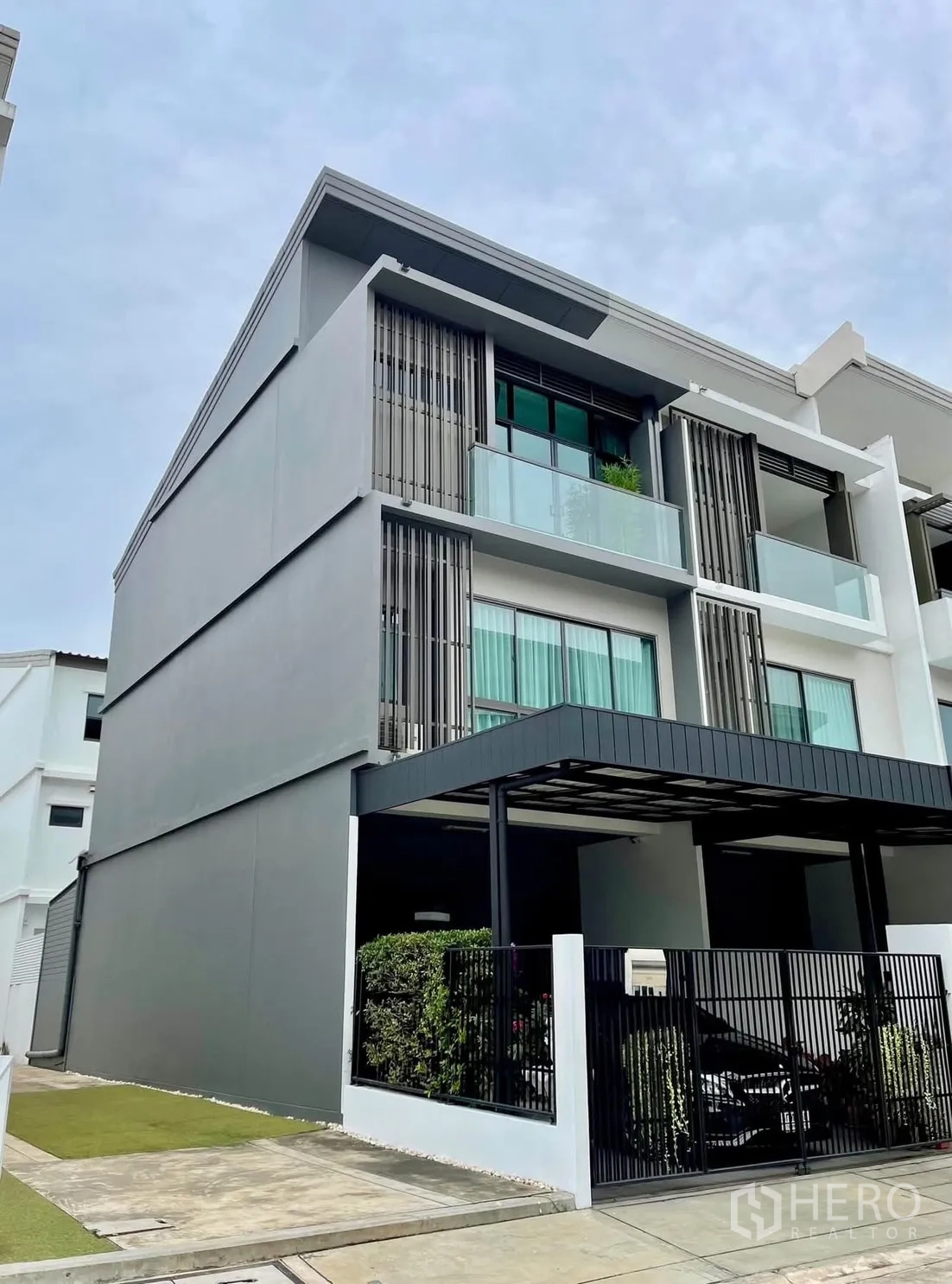 Townhouse for rent in Lat Phrao, Bangkok - Modern three-storey townhouse facade with balconies and carport.