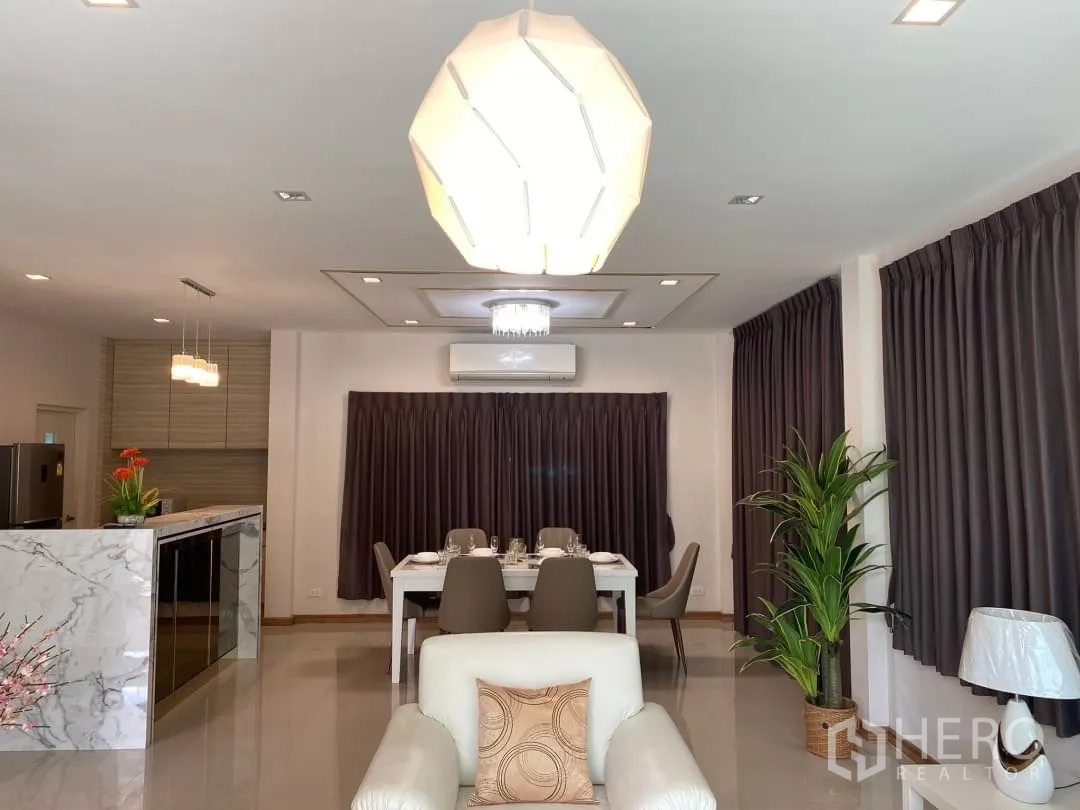 Detached House for rent or sale in Prawet, Bangkok - Open-plan living and dining space with large windows and indoor greenery.