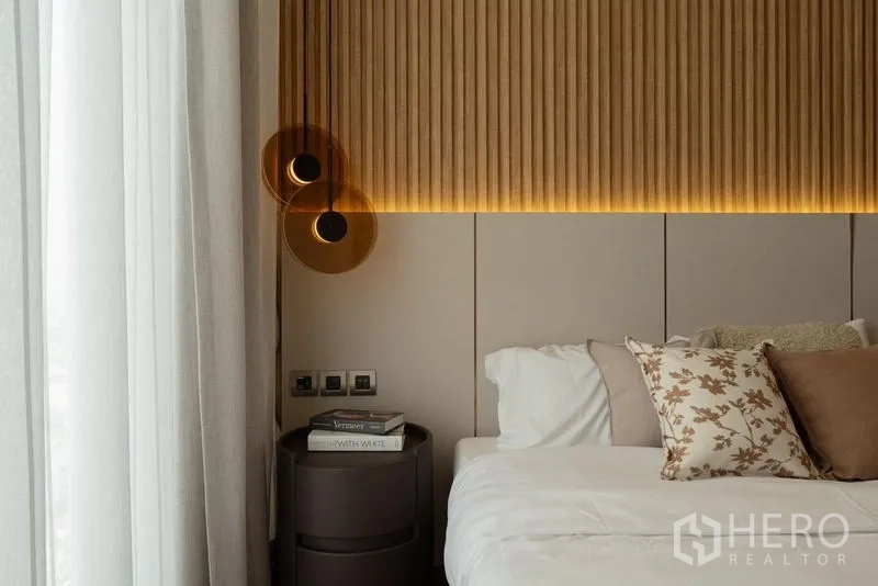 Condominium for rent in Watthana, Bangkok - Close-up of bedside with wooden slat headboard and modern pendant lights.
