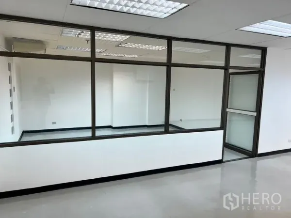 办公空间 出租在Pathum Wan, Bangkok - 白色办公区内的玻璃会议室，吊顶灯光与亮面地坪。