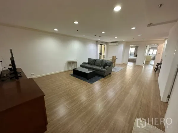 公寓 出租在Watthana, Bangkok - 开放式客餐区，筒灯与木地板营造通透空间。
