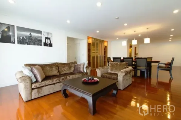 Condominium for rent in Watthana, Bangkok - Spacious living and dining area with plush sofas, polished wood floors and recessed lighting in a Watthana condo.
