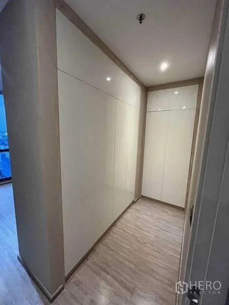 公寓 出租在Watthana, Bangkok - 走廊两侧为顶天立地的内置衣柜，浅色木地板。