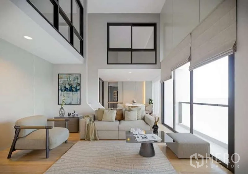 คอนโด ให้เช่าในHuai Khwang, Bangkok - ห้องนั่งเล่นเพดานสูงสว่าง โซฟาโทนอบอุ่นและกระจกชั้นลอย