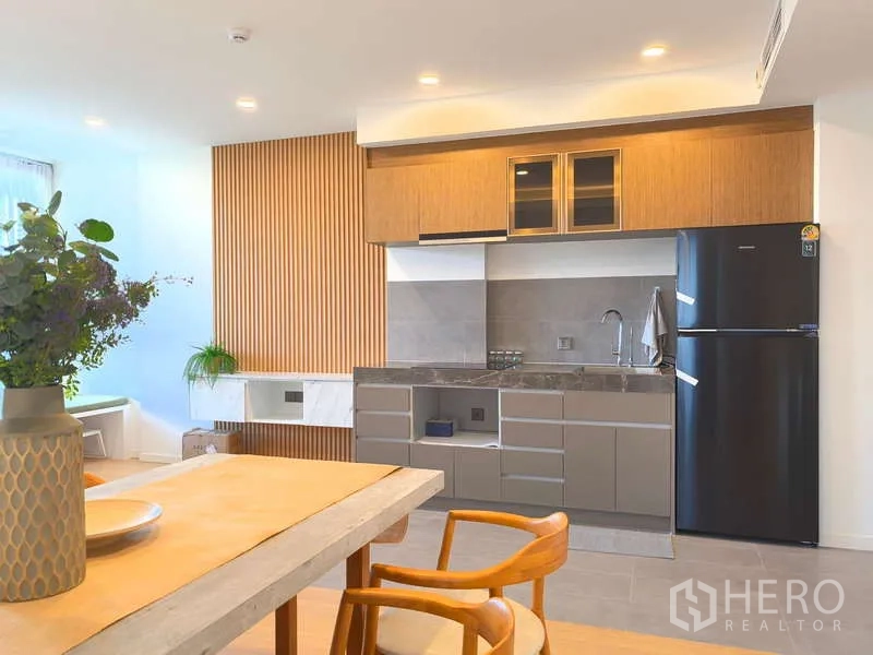 Apartment for rent - Open-plan kitchen with wood cabinets, stone countertop and full-size refrigerator.