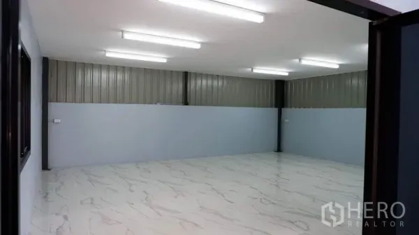 Warehouse for rent in Bueng Kum, Bangkok - Bright warehouse office room with marble-look tile floors and strip lighting.
