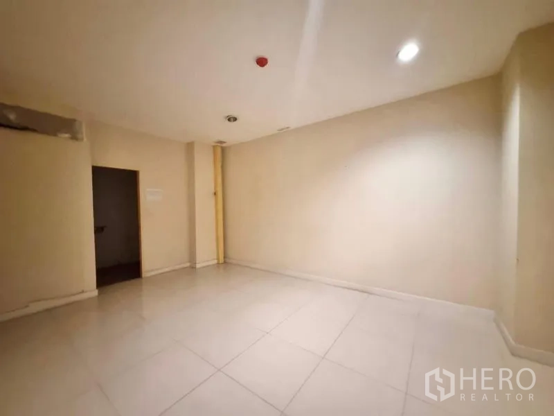 店屋 出租在Watthana, Bangkok - 米色空房，瓷砖地面与筒灯，适合作为办公室或理疗室。