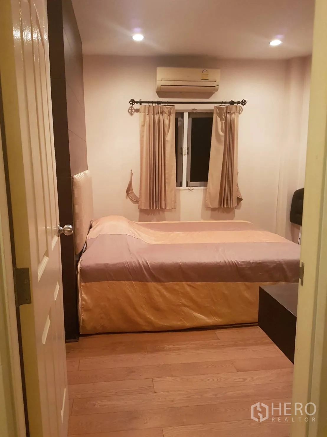 Detached House for sale in Lat Krabang, Bangkok - Compact bedroom with bed, window curtains and wall-mounted air conditioner.