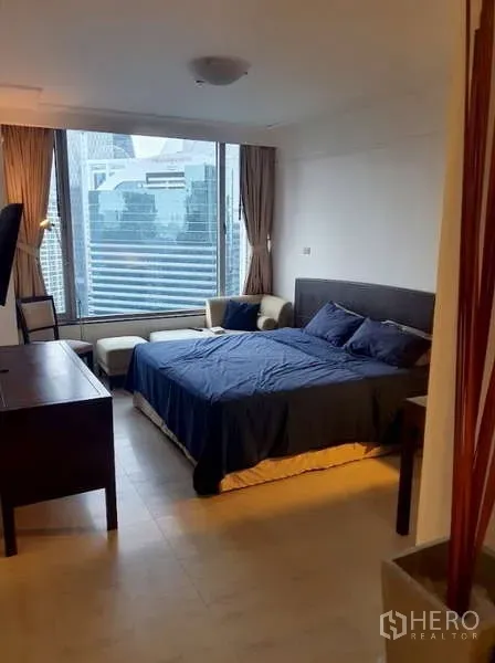Condominium for sale in Pathum Wan, Bangkok - Bright bedroom with large window, city view and seating area