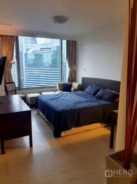 Condominium for sale in Pathum Wan, Bangkok - Bright bedroom with large window, city view and seating area