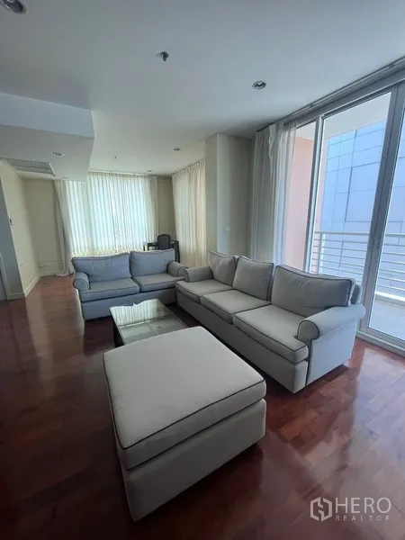 公寓 出租在Khlong Toei, Bangkok - 客厅配双人沙发与茶几，推拉落地门通向阳台，曼谷公寓。