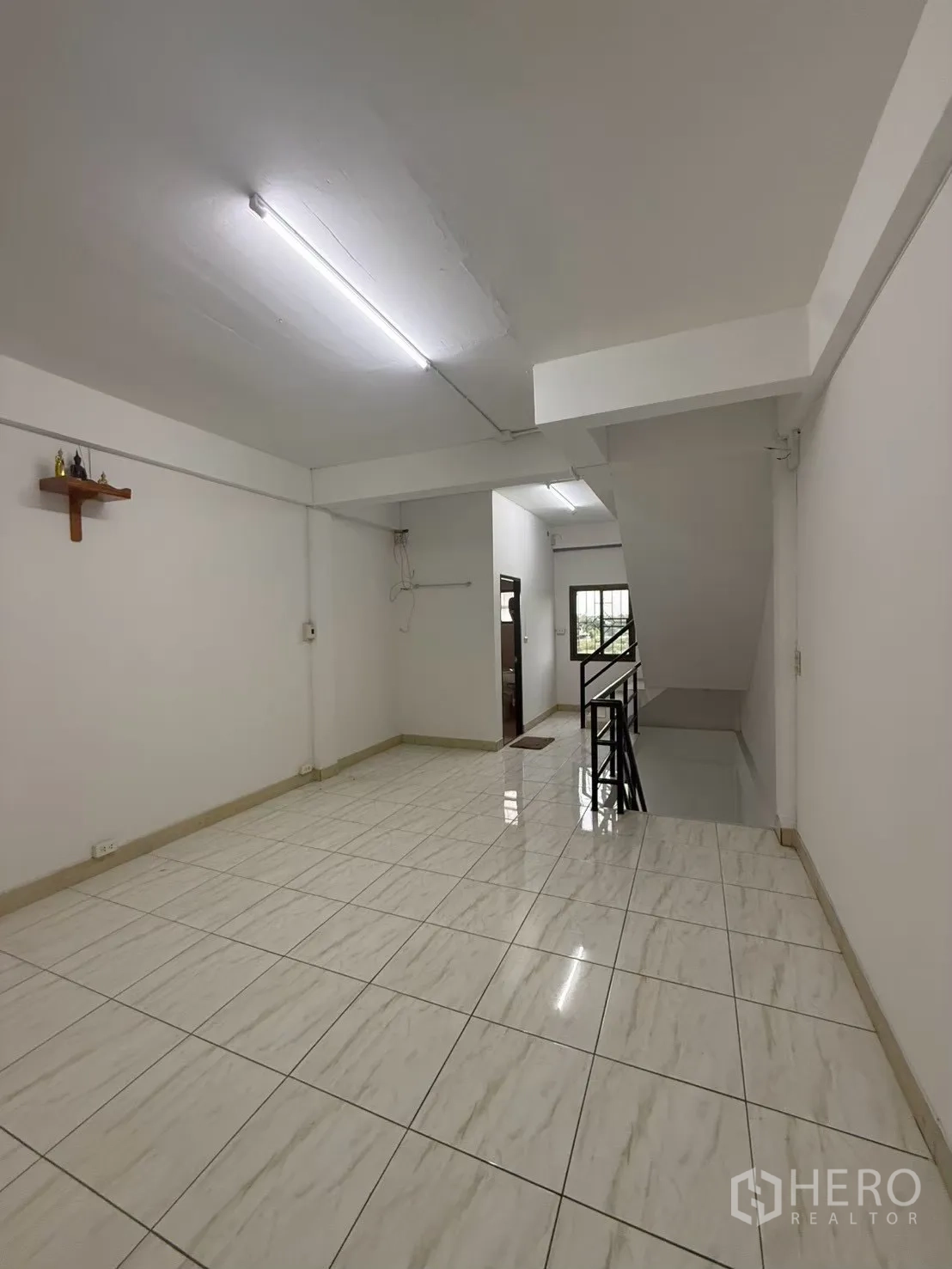 Shophouse for rent in Pak Kret, Nonthaburi - Upper-floor landing with white tiles and stair railing.