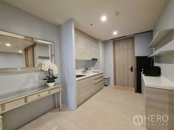 公寓 出租在Pathum Wan, Bangkok - 内置厨房，浅木色柜体，大镜面玄关台、冰箱与开放式置物架。