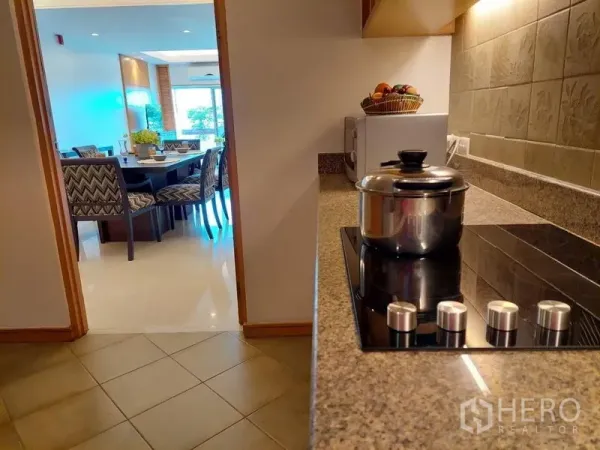 Apartment for rent - Granite countertop with electric cooktop leading to a dining room set for six.