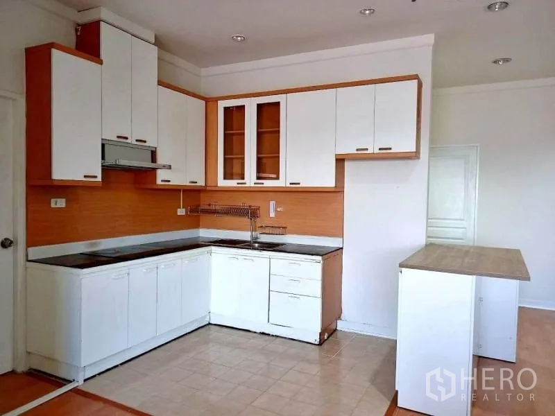 Condominium for rent in Khlong Toei, Bangkok - Bright corner kitchen with glass-front cabinets, cooktop and ample storage.