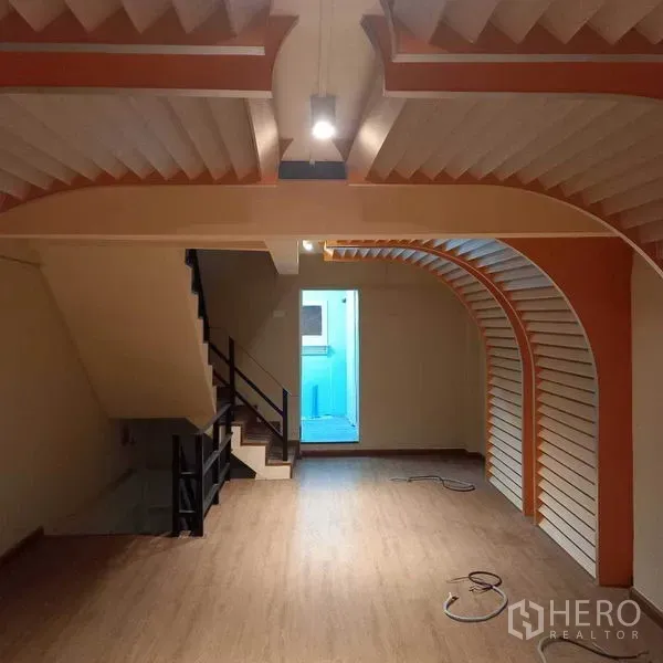 Shophouse for rent in Watthana, Bangkok - Retail floor with staircase and curved feature walls leading to a back room