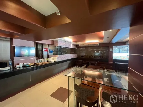 Retail Space for rent or sale in Khlong Toei, Bangkok - Restaurant-style serving counter with glass display and dining tables within the retail unit.