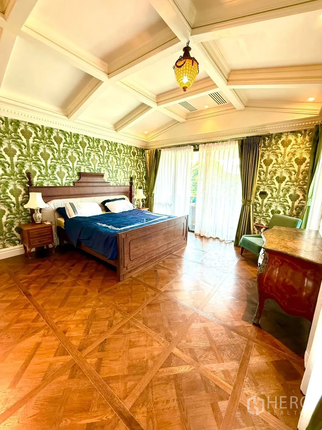 Detached House for rent in Bang Kapi, Bangkok - Spacious bedroom with coffered ceiling, patterned wallpaper, and large windows.