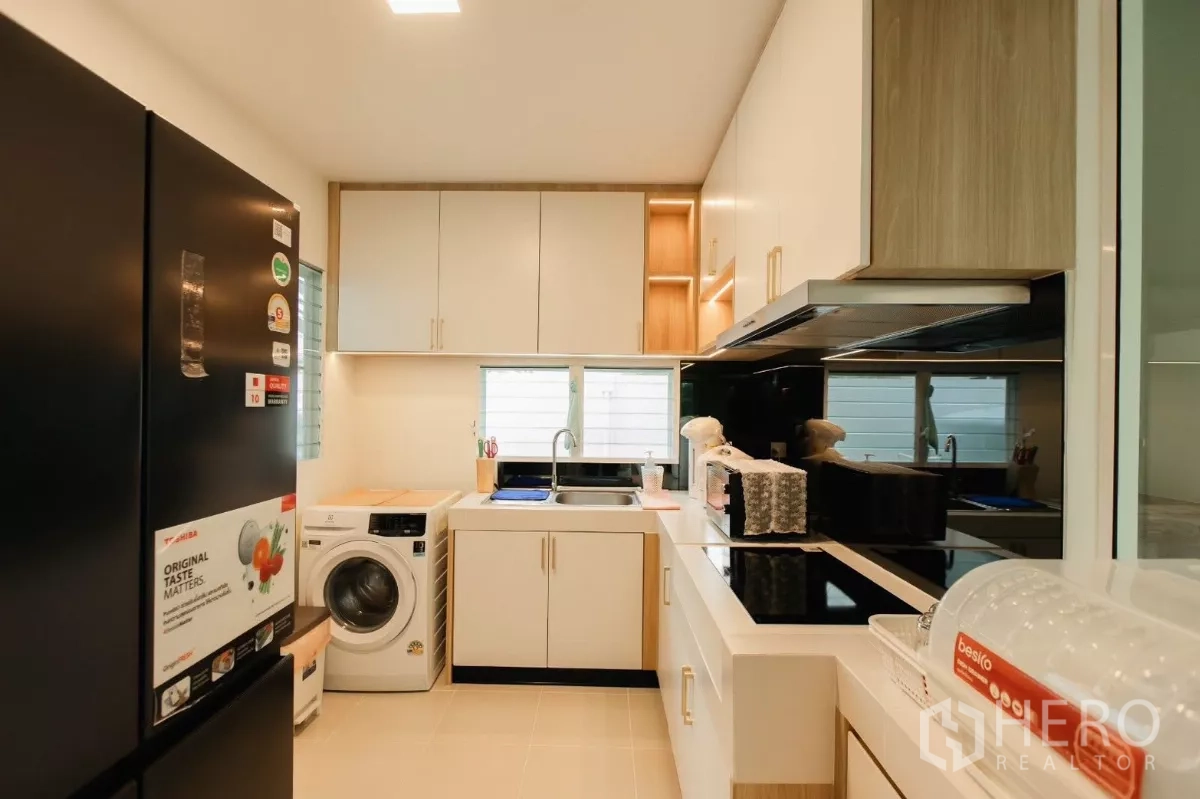 บ้าน ให้เช่าหรือขายในBang Phli, Samut Prakan - อีกมุมของครัวพร้อมตู้เย็นสีดำ อ่างล้างจาน เครื่องซักผ้า และพื้นที่เก็บของ