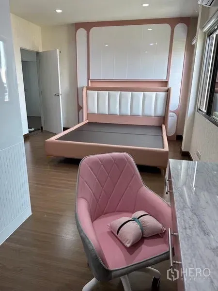 Detached House for sale in Saphan Sung, Bangkok - Cozy bedroom with pink upholstered bed, marble desk and chair.