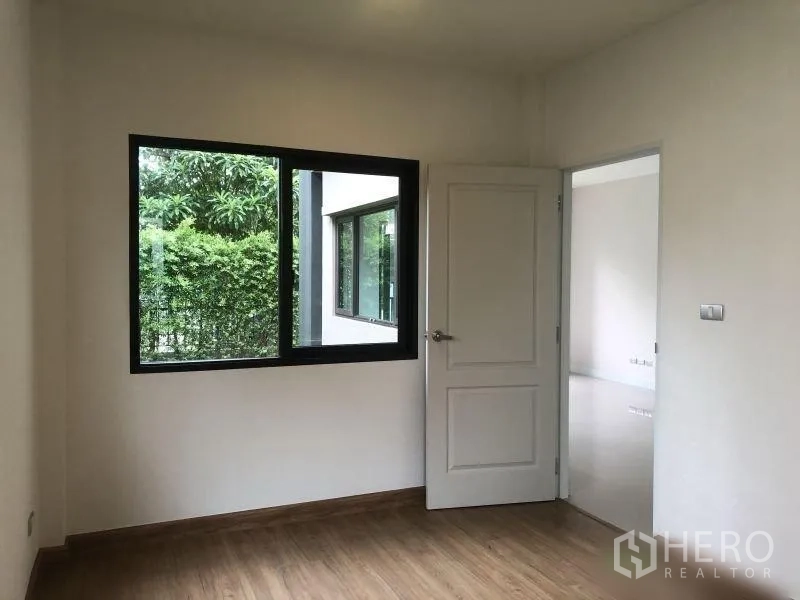 Detached House for sale in Bang Phli, Samut Prakan - Ground-floor bedroom with large window overlooking green hedges