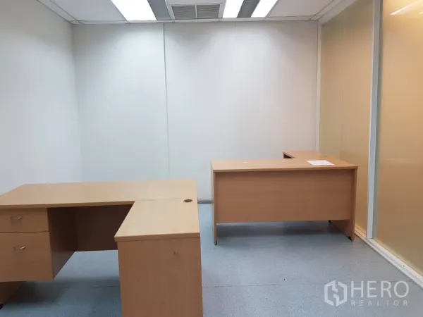 办公空间 出租在Bang Na, Bangkok - 带两张L形办公桌的独立办公室，磨砂玻璃隔断与嵌入式照明。